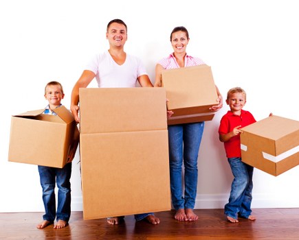 Movers carrying furniture down stairs in a Haringey flat